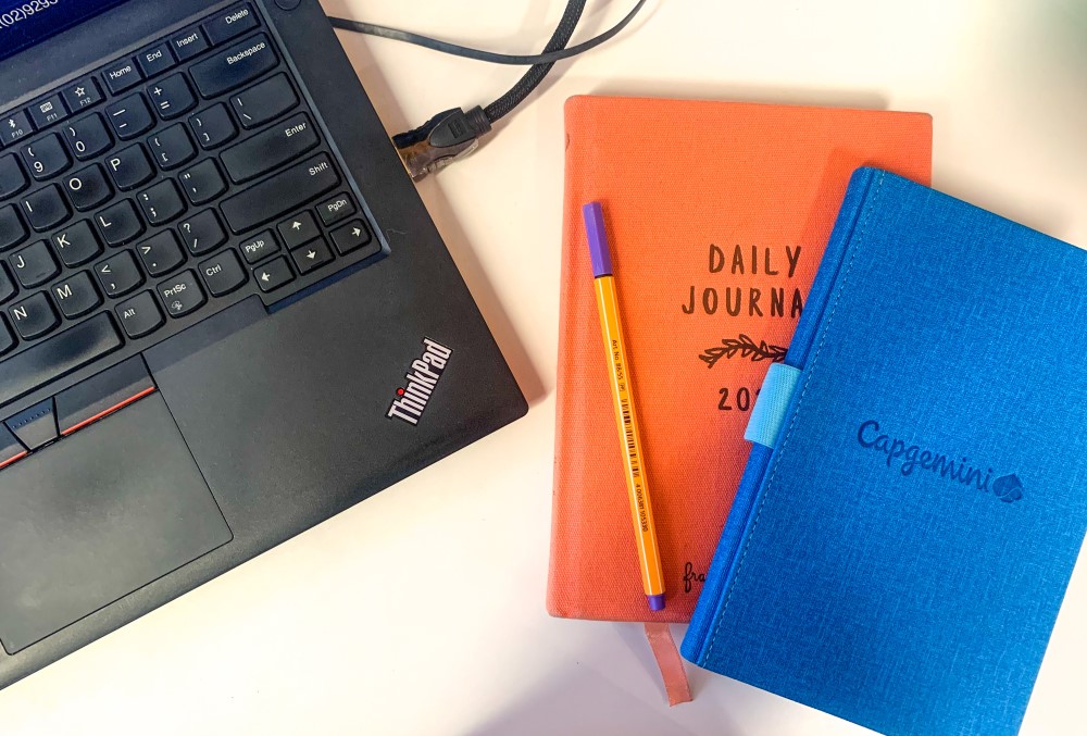 Capgemini Australia Graduate - Laptop and two journals laid on a table