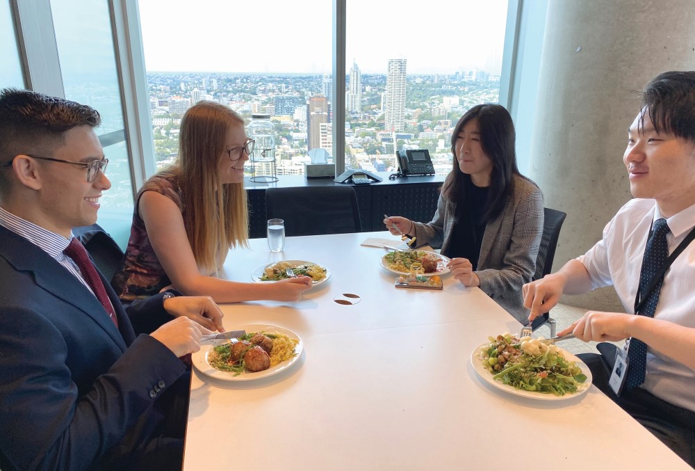 Male graduate having lunch with colleagues